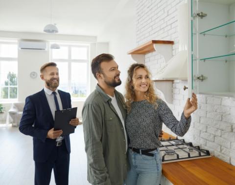 A couple viewing a property with an estate agent. 